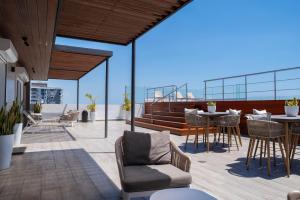 a balcony with chairs and tables on a roof at Torre Opus 31 - Apto.605 in Santo Domingo