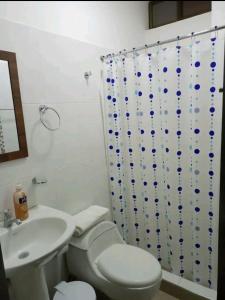 a bathroom with a white toilet and a sink at Sky Blue Apartments in Manta