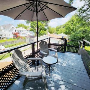 two chairs and a table with an umbrella on a deck at Sports Retreat, Mins to Cedar Pt, Sports Force & Ferry, Private Deck, EV, Kids & Pet Friendly in Sandusky