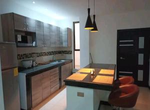 a kitchen with a counter and a chair in it at Sky Blue Apartments in Manta