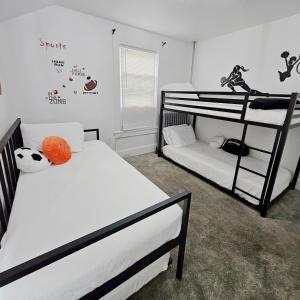 a bedroom with two bunk beds and a window at Sports Retreat, Mins to Cedar Pt, Sports Force & Ferry, Private Deck, EV, Kids & Pet Friendly in Sandusky