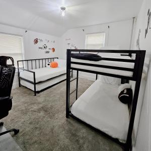 a bedroom with two bunk beds in a room at Sports Retreat, Mins to Cedar Pt, Sports Force & Ferry, Private Deck, EV, Kids & Pet Friendly in Sandusky