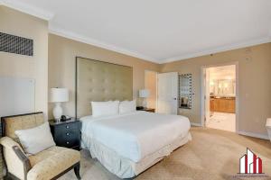 a large bedroom with a large bed and a chair at MGM Signature-18-701 1Br2Ba Strip View Balcony in Las Vegas