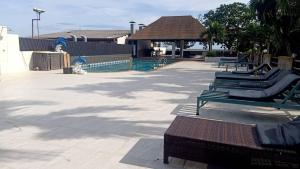uma piscina com espreguiçadeiras ao lado de um resort em Days Inn by Wyndham Aonang Krabi em Praia de Aonang