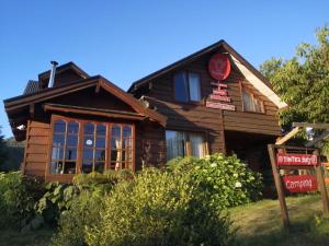 a wooden house with a sign in front of it at Hostal Tintica Buey Puerto Fuy in Puerto Fuy