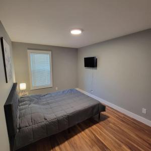 a bedroom with a bed and a flat screen tv at Beautiful Renovated 4 Bedroom. Walk to Niagara Falls. in Niagara Falls