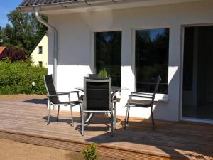 a patio with a table and chairs on a deck at Ferienwohnung in Patzig auf Rügen in Patzig