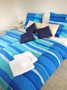 Cama azul y blanca con sábanas y almohadas azules y blancas en Ferienwohnung in Patzig auf Rügen, en Patzig