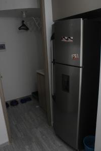 eine Küche mit Kühlschrank in einem Zimmer in der Unterkunft HERMOSO APTO EN CLUB HOUSE- RICAURTE CUNDINAMARCA in Ricaurte