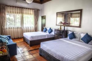 a hotel room with two beds and a couch at VILLA MASSILIA in Siem Reap