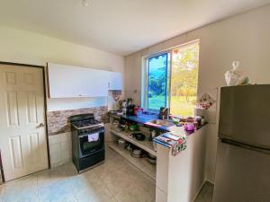 a kitchen with a sink and a stove and a window at Casa Campestre Laguna Verde in Villavicencio