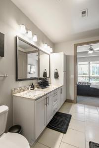 a bathroom with a sink and a toilet and a mirror at Luxurious Downtown Apartment in Atlanta