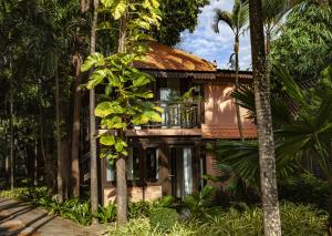 a house with a balcony in the middle of trees at VILLA MASSILIA in Siem Reap