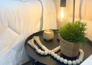 a table with a candle and a potted plant on it at Loft luxuoso na Serra - Granja Brasil Resort in Petrópolis