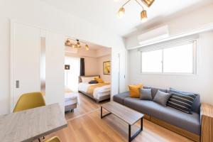 a living room with a couch and a bed at SG RESIDENCE INN HAKATA in Fukuoka