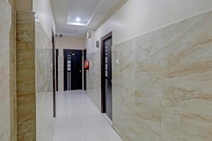 a hallway with marble walls and a hallway with black doors at Hotel White Ridge Near Kondapur in Kondapur