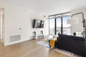 a living room with a black couch and a tv at Luxury Living In Buckhead in Atlanta