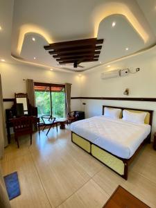 - une chambre avec un grand lit et un bureau dans l'établissement JEEVAN HOMESTAY kovalam, à Kovalam
