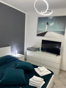 a bedroom with a bed and a tv and a lighthouse at La perla del mare in Fiumicino