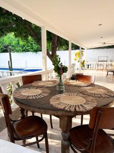 uma mesa de madeira e cadeiras num quarto com um pátio em Casa campestre con piscina cerca al aeropuerto y la playa em Santa Marta