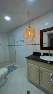 uma casa de banho com um lavatório, um WC e um espelho. em Casa campestre con piscina cerca al aeropuerto y la playa em Santa Marta