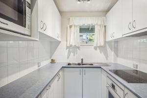 スレッドボにあるTyrola 2のシンクと窓のある白いキッチン +13枚の写真