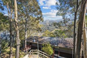 a house in the woods with mountains in the background at Tyrola 2 in Thredbo