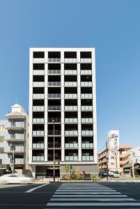 un grand bâtiment blanc dans une rue de la ville dans l'établissement SG RESIDENCE INN HAKATA, à Fukuoka