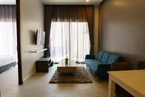 a living room with a blue couch in front of a window at Luxury Lake Condo next to Beach in Rawai Beach