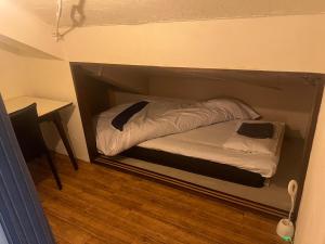 uma pequena cama num canto de um quarto em Guest House Ichiyama Shukuba em Matsumoto