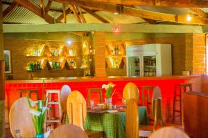 a restaurant with a table and chairs and a red wall at Swiss Farm Cottage in Lushoto