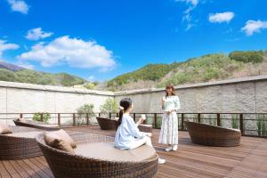two women are sitting on a deck on a roof at TAOYA Kisoji in Nagiso