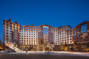 a large building at night with snow in front of it at Wanda Momoland Changbaishan in Sanjiaocheng