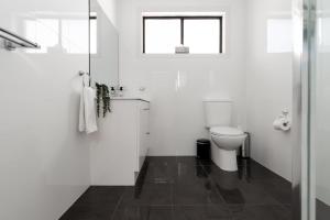une salle de bain blanche avec toilettes et fenêtre dans l'établissement Homely Hideaway with Parking & WiFi, à Alanvale 22 autres photos
