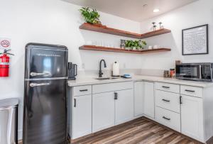 a kitchen with white cabinets and a stainless steel refrigerator at Peyton's Luxury Suite in Oakhurst