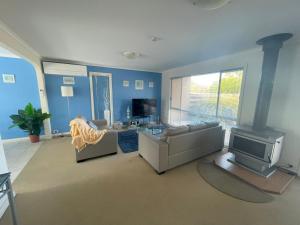 uma sala de estar com um sofá e uma lareira em The Esplanade 4 em Inverloch