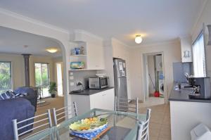 a kitchen and living room with a glass table at The Esplanade 4 Free Wifi And Foxtel in Inverloch
