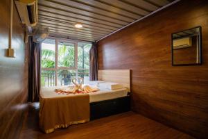 a bedroom with a bed in a room with a window at Paya Debloc Village in Tioman Island