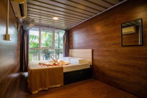 ein Schlafzimmer mit einem Bett in einem Zimmer mit einem Fenster in der Unterkunft Paya Debloc Village in Tioman Island
