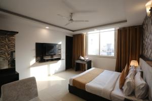 a hotel room with a bed and a television at Hotel Aashiyana Palace Just 4Km Away From Delhi Airport in New Delhi