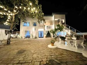 a large white building with a courtyard at night at Evergreen Tree Homestay in Phan Thiet