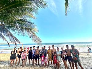 a group of people posing for a picture on the beach at Evergreen Tree Homestay in Phan Thiet