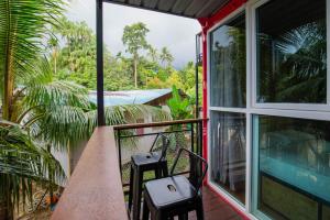 two chairs on the balcony of a house at Paya Debloc Village in Tioman Island
