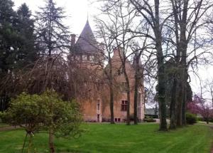 un gran edificio de ladrillo con árboles delante de él en Maison d'une chambre avec jardin clos a Thoisy la Berchere, en Thoisy-la-Berchère