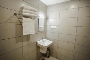 AthirappillyAthirappilly Rainland Resort的带水槽、马桶和毛巾的浴室