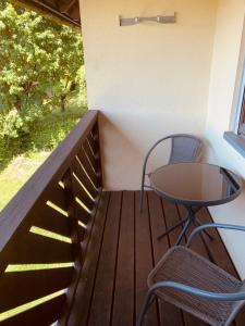 Balcón de madera con mesa y sillas en FELIX LIVING 8, modern & cozy, 3 Zimmer, Balkon, Parkplatz, en Salzweg