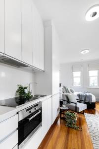 een keuken met witte kasten en een woonkamer bij Designer Styled Studio in Central Trendy Glebe in Sydney