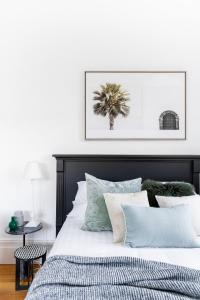 een slaapkamer met een bed met een zwart hoofdeinde en kussens bij Designer Styled Studio in Central Trendy Glebe in Sydney