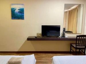 a room with a desk with a flat screen tv at Syaz Meridien Hotel in Malacca