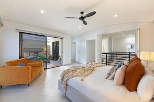 a bedroom with a large bed and a living room at Marina View - Waterfront Stunner with Plunge Pool in Darwin
